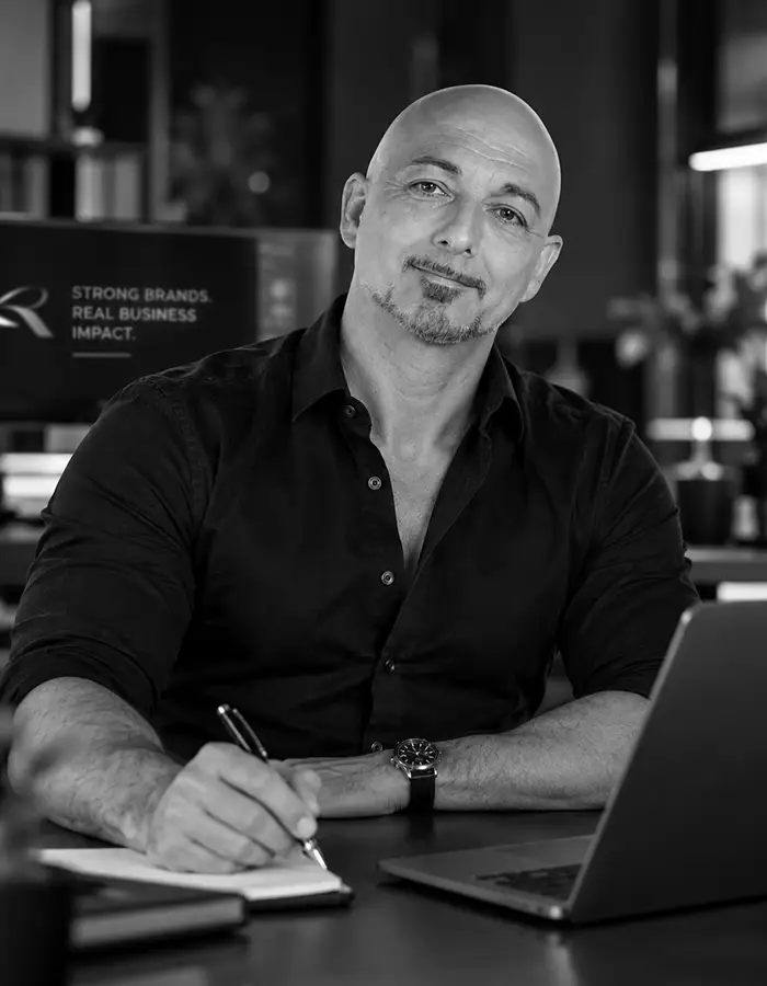 Sandro Renk, Inhaber der Agentur für Webdesign und Markenaufbau, sitzend am Schreibtisch vor dem Notebook